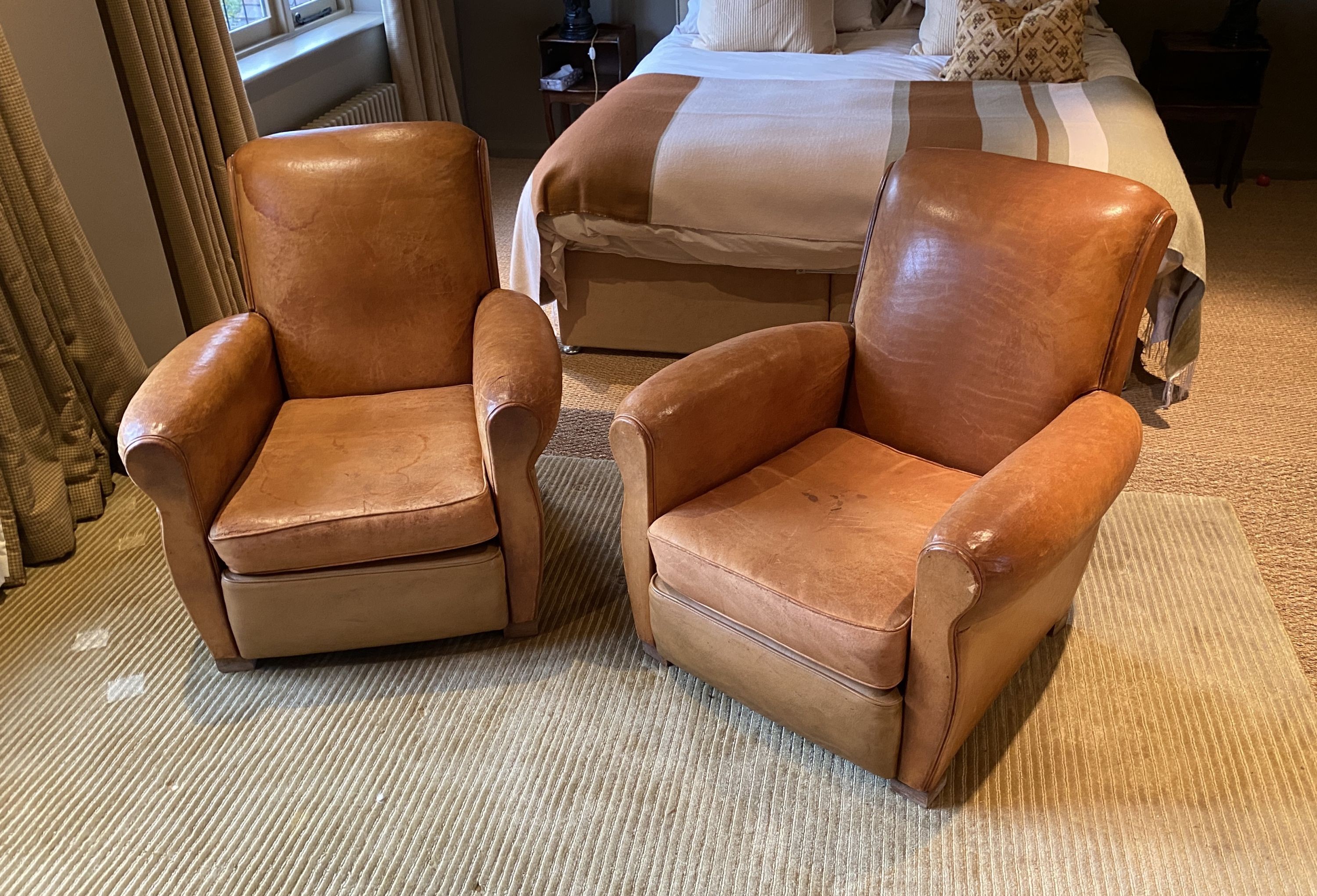 A pair of 1940's French tan leather upholstered armchairs, width 82cm depth 92cm height 84cm